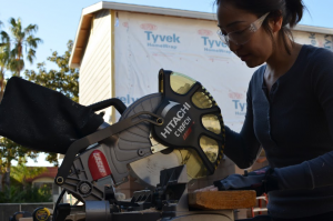 Emi working on building a house for Habitat for Humanity. Her other passions are volunteering for the Annual Popsicle Stick Bridge Competition and CANstruction.